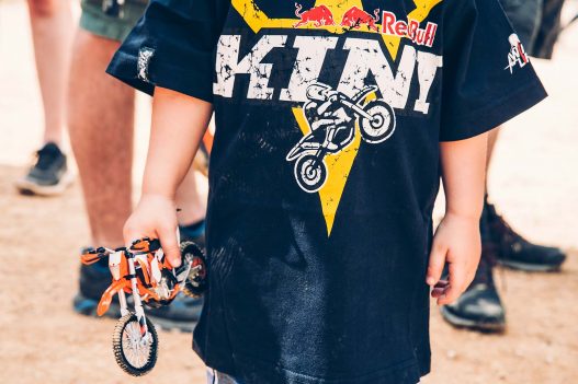 Kind mit Red Bull Tshirt und Bike in der Hand