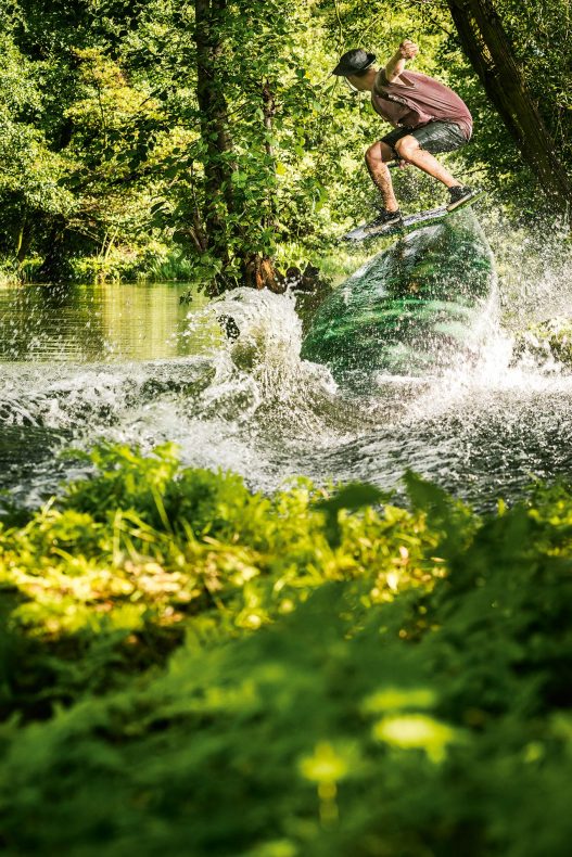 Wakeboarder in Action auf See im Wald