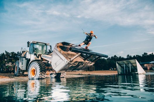 Wakeboarder springt über Bagger